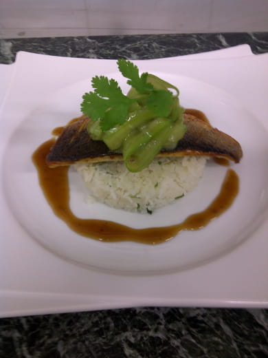 Pan-fried sea bass fillet with coriander rice cake, cucumber ribbons and Thai broth