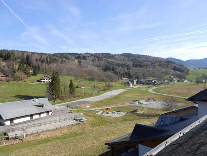 View from the gîte of the games area (swings, climbing wall - slide set, tennis court, playground, ping pong table)